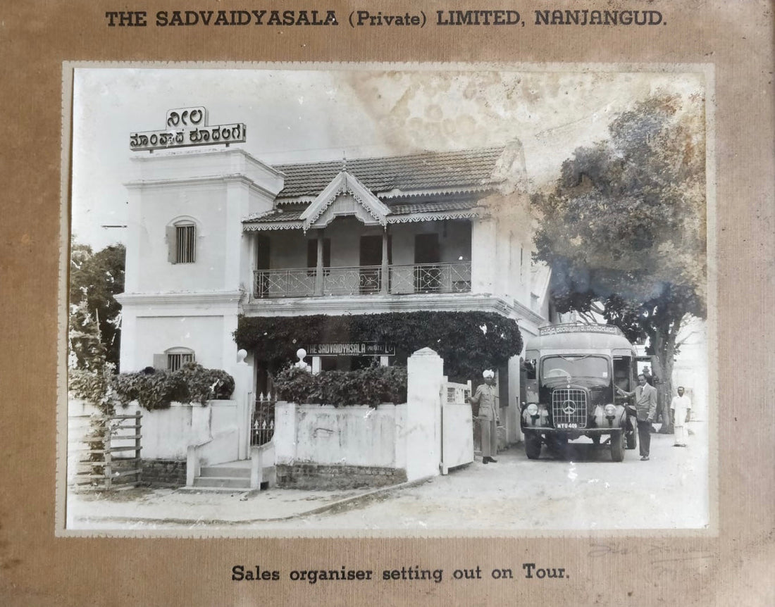 Vintage photo of Sadvaidyasala Pvt. Ltd. building in Nanjangud with sales organizer truck departing on tour, circa early 20th century
